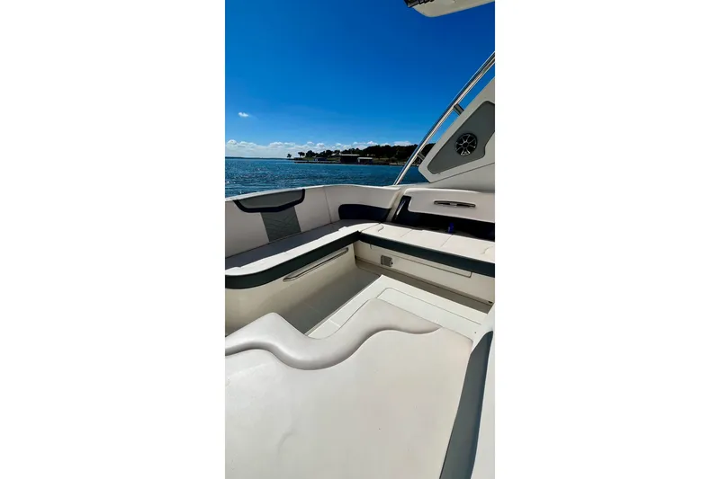 Slide: The Image of 2019 Chaparral 347 SSX boat interior with seating, under a clear blue sky. - 19