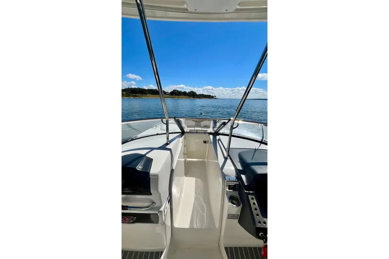 Slide: The Image of 2019 Chaparral 347 SSX boat on calm water under clear blue sky. - 26