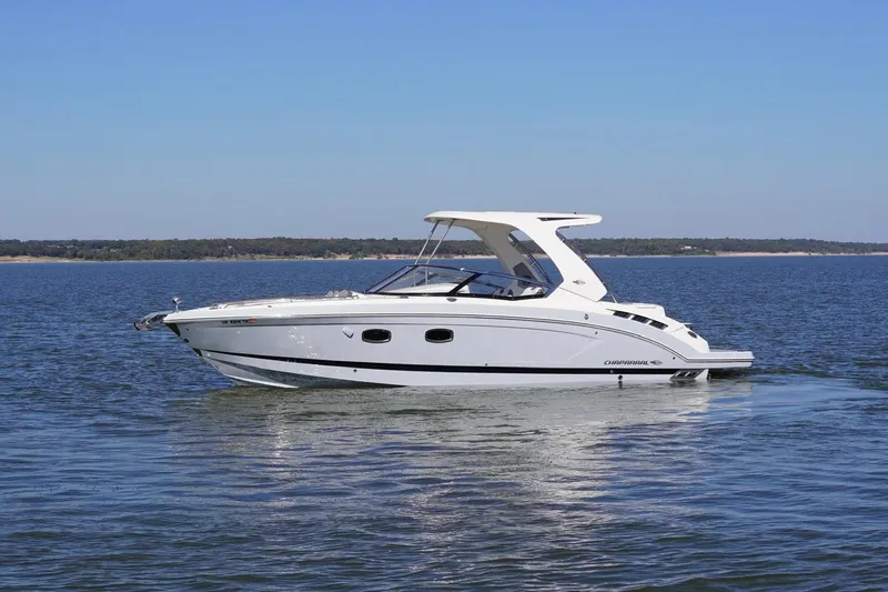 Slide: The Image of 2019 Chaparral 347 SSX boat cruising on a calm lake under a clear blue sky. - 3