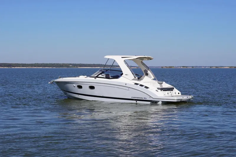 Slide: The Image of 2019 Chaparral 347 SSX boat cruising on a calm lake under clear blue skies. - 4