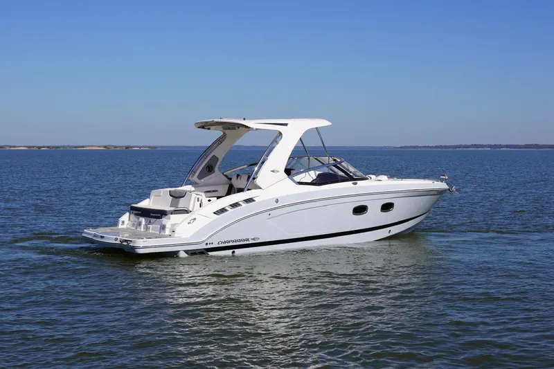 Slide: The Image of 2019 Chaparral 347 SSX boat cruising on a calm lake under a clear blue sky. - 7