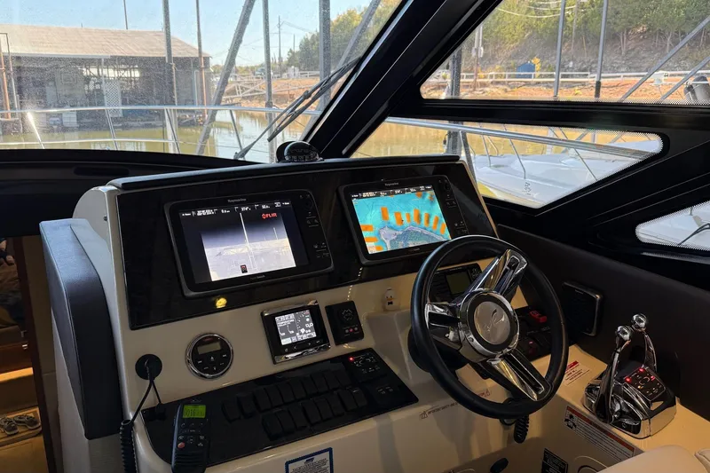 Slide: The Image of Helm of 2015 Sea Ray 470 Sundancer with advanced navigation displays and controls. - 17