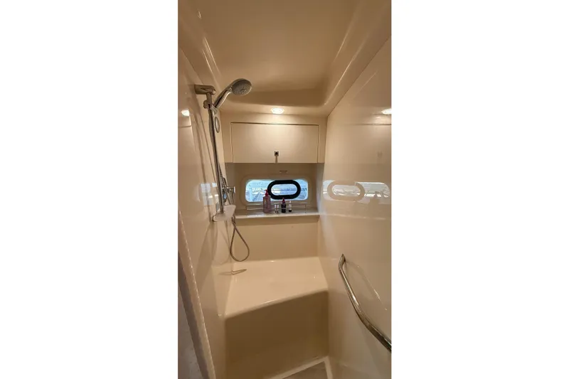 Slide: The Image of Shower area in 2015 Sea Ray 470 Sundancer yacht, featuring modern fixtures and porthole window. - 31