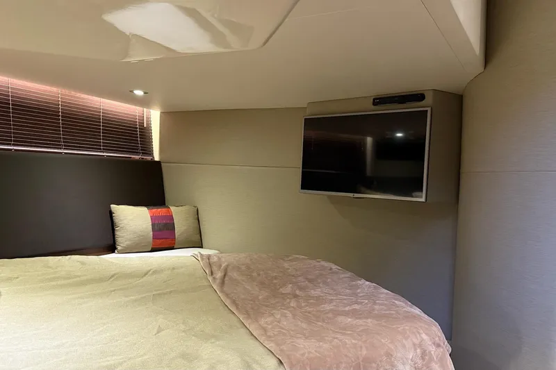 Slide: The Image of Luxurious cabin interior of 2015 Sea Ray 470 Sundancer with bed and wall-mounted TV. - 40