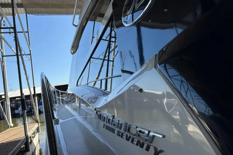 Slide: The Image of 2015 Sea Ray 470 Sundancer yacht docked, showcasing sleek design and reflective surfaces. - 44