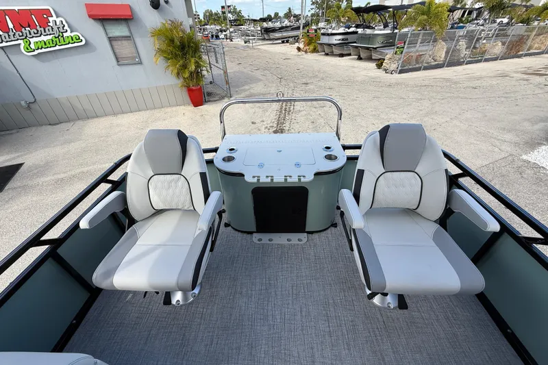 Slide: The Image of 2026 Avalon 2385 Venture boat with center console and two swivel seats, parked at a marina. - 22