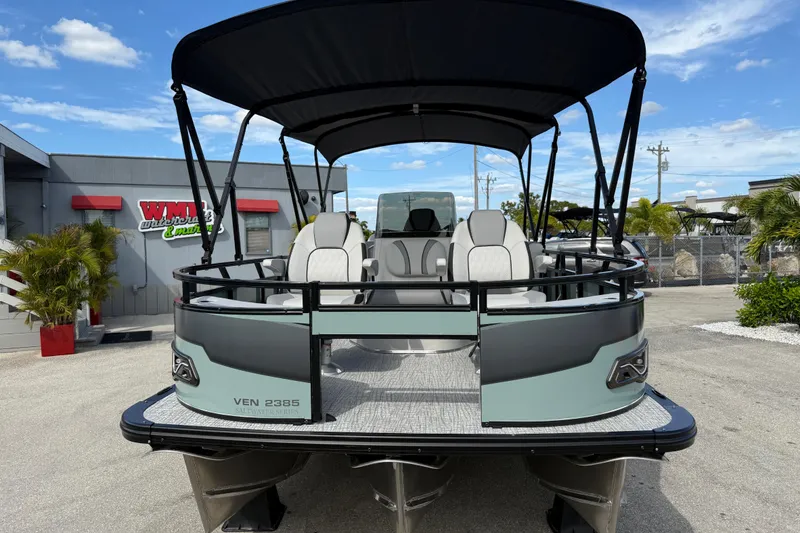 Slide: The Image of 2026 Avalon 2385 Venture Center Console Fish Tri Toon boat with canopy, parked outdoors. - 3