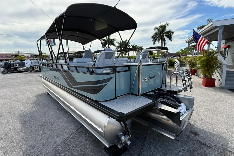 Slide: The Image of 2026 Avalon 2385 Venture 85 Tri Toon boat with center console, parked outdoors under a clear sky. - 8