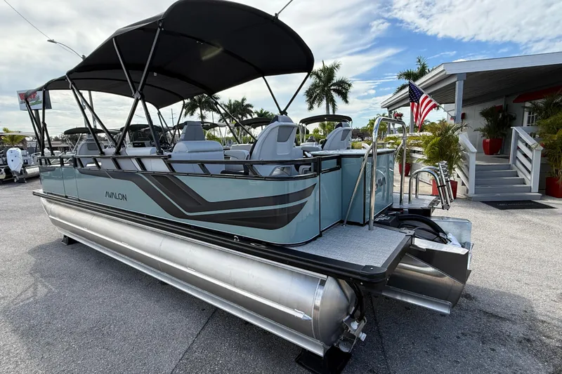 Slide: The Image of 2026 Avalon 2385 Venture 85 Tri Toon boat with center console, parked outdoors. - 9