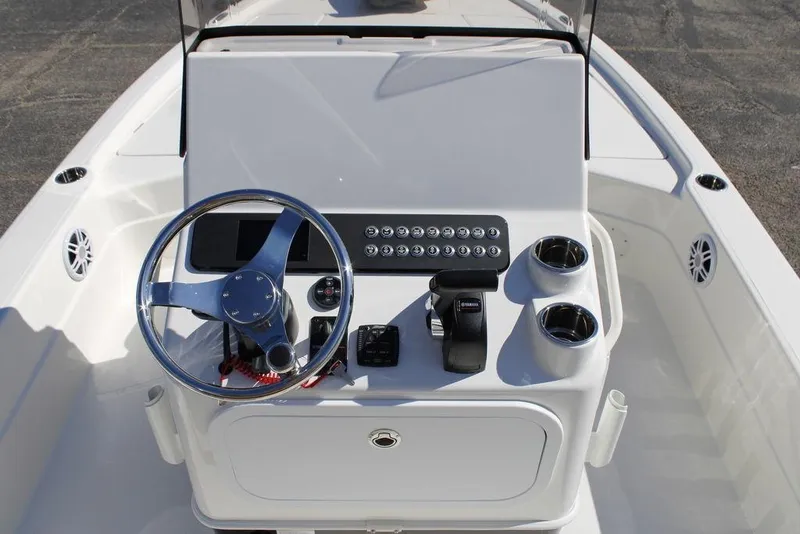 Slide: The Image of 2026 Skeeter SX241 boat console with steering wheel, controls, and cup holders. - 16