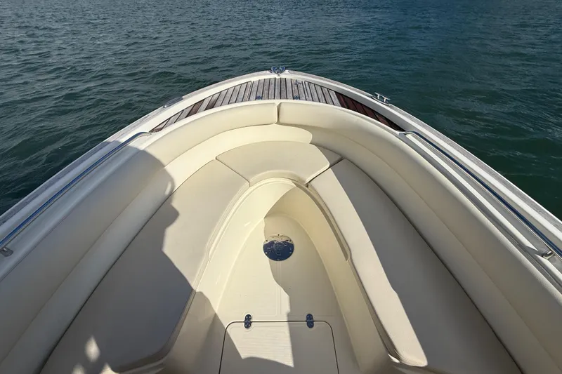 Slide: The Image of 2013 Chris-Craft Catalina 26 boat bow with cushioned seating on calm water. - 13