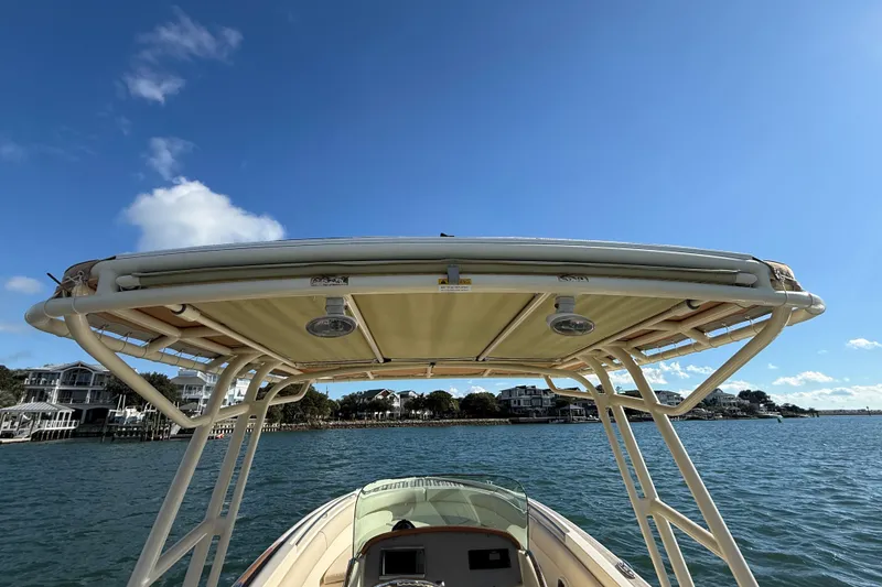 Slide: The Image of 2013 Chris-Craft Catalina 26 boat on water, featuring a sturdy canopy under a clear blue sky. - 14