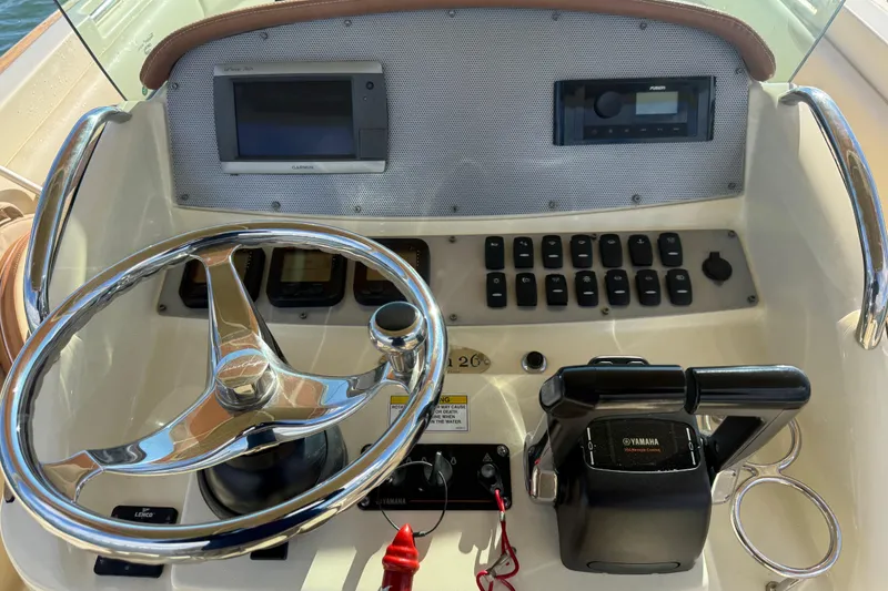 Slide: The Image of 2013 Chris-Craft Catalina 26 dashboard with steering wheel, controls, and navigation equipment. - 16