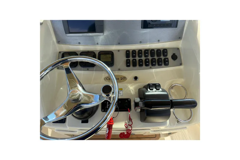 Slide: The Image of 2013 Chris-Craft Catalina 26 helm with steering wheel and control panel. - 17