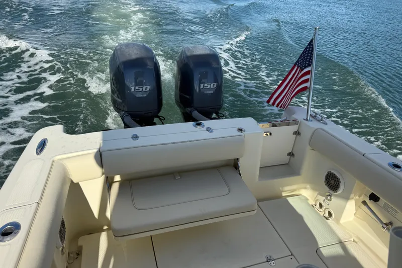 Slide: The Image of 2013 Chris-Craft Catalina 26 with twin Yamaha 150 engines and American flag on water. - 20