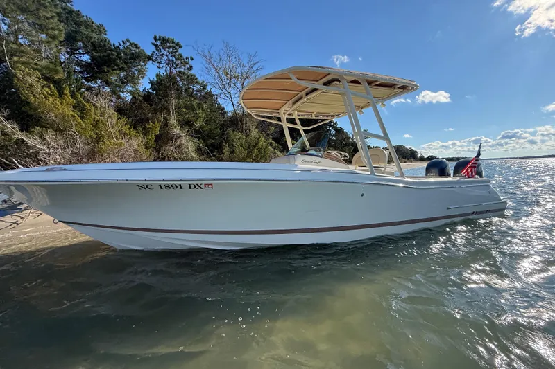 Slide: The Image of 2013 Chris-Craft Catalina 26 boat on water, sunny day, trees in background. - 6