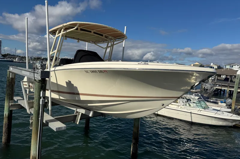 Slide: The Image of 2013 Chris-Craft Catalina 26 boat on lift, docked in marina under blue sky. - 8