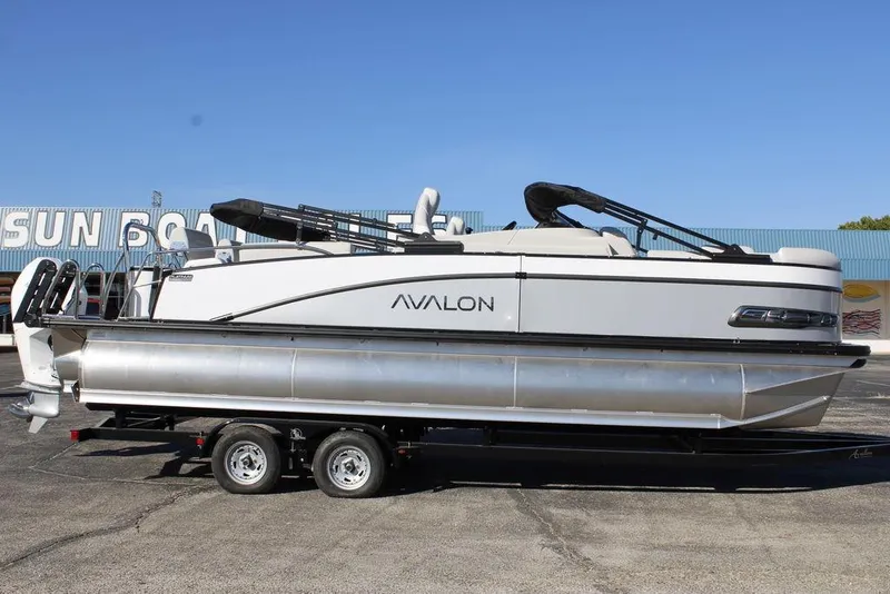 The Image of 2026 Avalon CATALINA 23 pontoon boat on trailer, parked outdoors. - 0