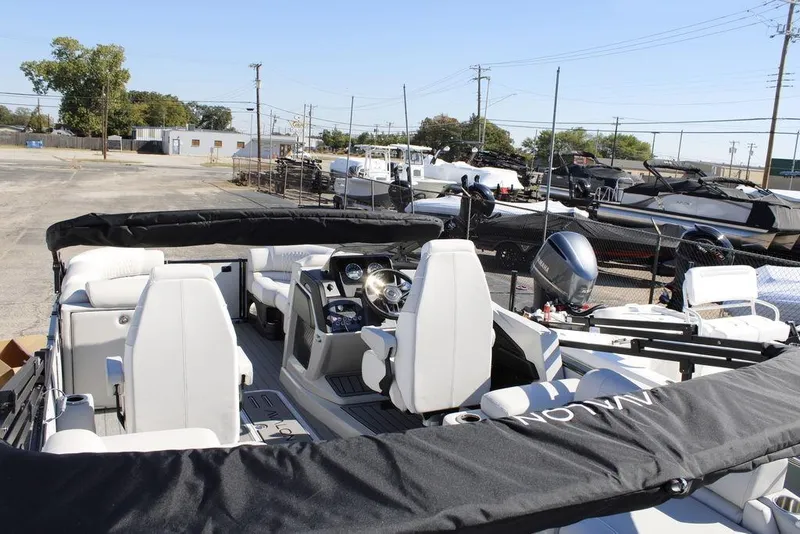 Slide: The Image of 2026 Avalon Catalina 23 boat interior with white seating and steering console in a marina. - 15