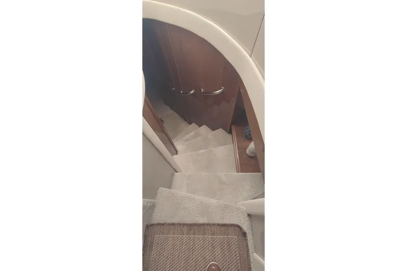 Slide: The Image of Staircase inside 2007 Carver 52 Voyager yacht with carpeted steps and wooden handrails. - 17