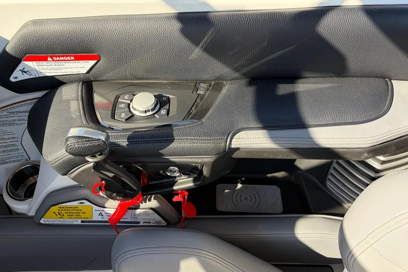 Slide: The Image of 2020 Nautique Super Air Nautique G23 boat control panel with steering and warning labels. - 48