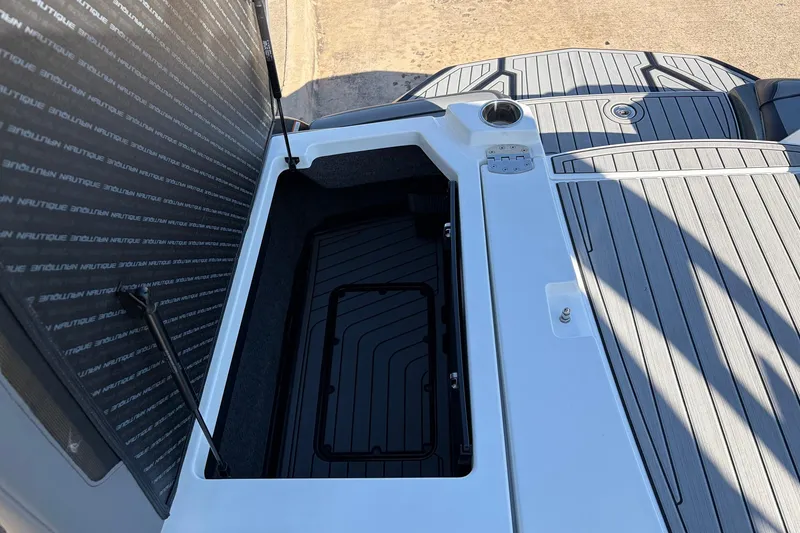 Slide: The Image of 2020 Nautique Super Air Nautique G23 boat storage compartment with open hatch and sleek design. - 54