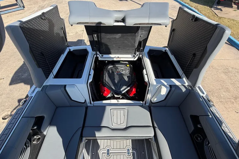 Slide: The Image of 2020 Nautique Super Air Nautique G23 boat engine compartment with open storage hatches. - 56