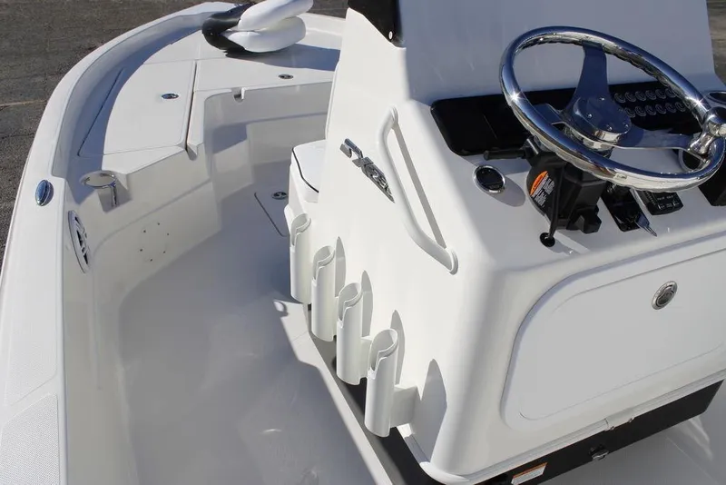 Slide: The Image of 2026 Skeeter SX230 boat interior with steering wheel and rod holders. - 19