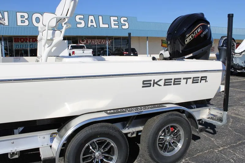 Slide: The Image of 2026 Skeeter SX230 boat on trailer outside dealership, featuring sleek design and powerful engine. - 2