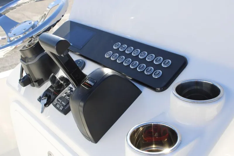 Slide: The Image of 2026 Skeeter SX230 boat console with steering wheel, controls, and cup holders. - 21