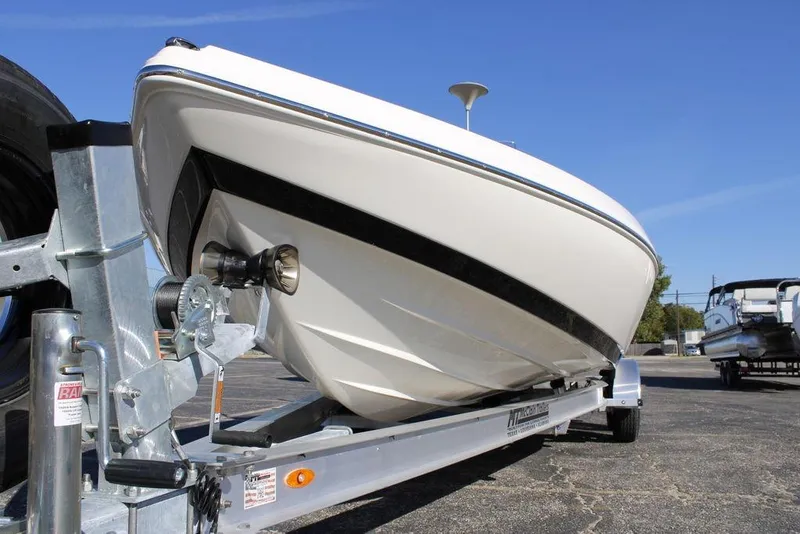 Slide: The Image of 2026 Skeeter SX230 boat on trailer under clear blue sky. - 9
