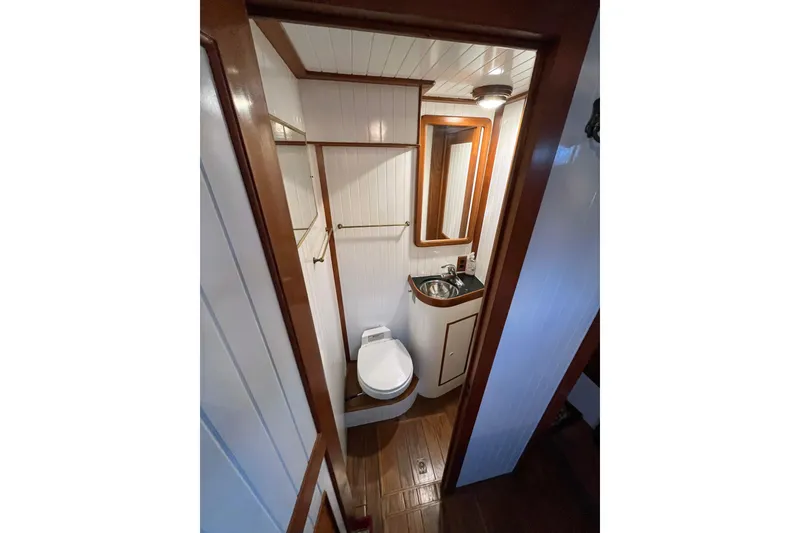 Slide: The Image of Compact bathroom in 1987 Liberty Gatsby boat with wood accents and modern fixtures. - 11