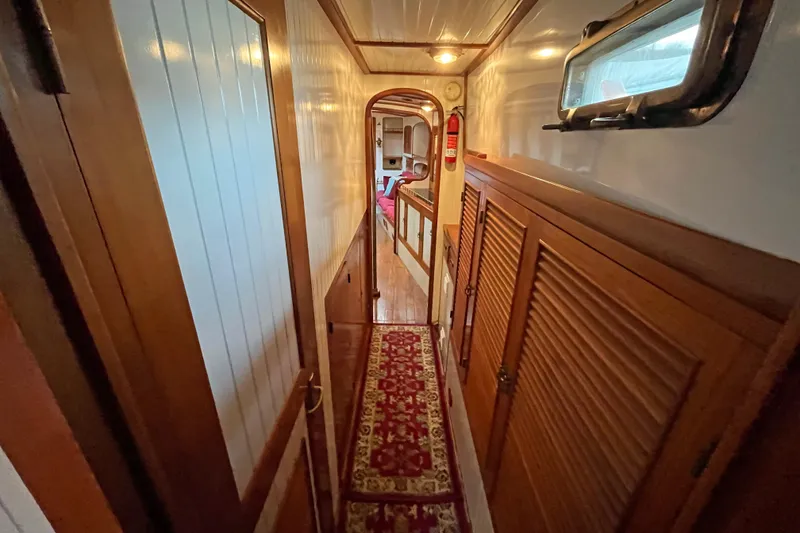 Slide: The Image of Narrow hallway inside 1987 Liberty Gatsby boat, featuring wood paneling and red carpet. - 12
