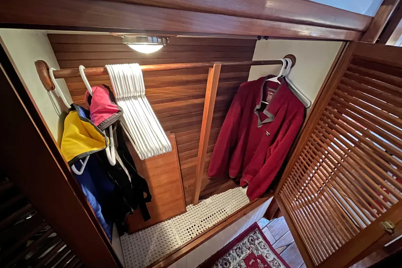 Slide: The Image of Wooden closet interior on 1987 Liberty Gatsby boat with clothes and hangers. - 13