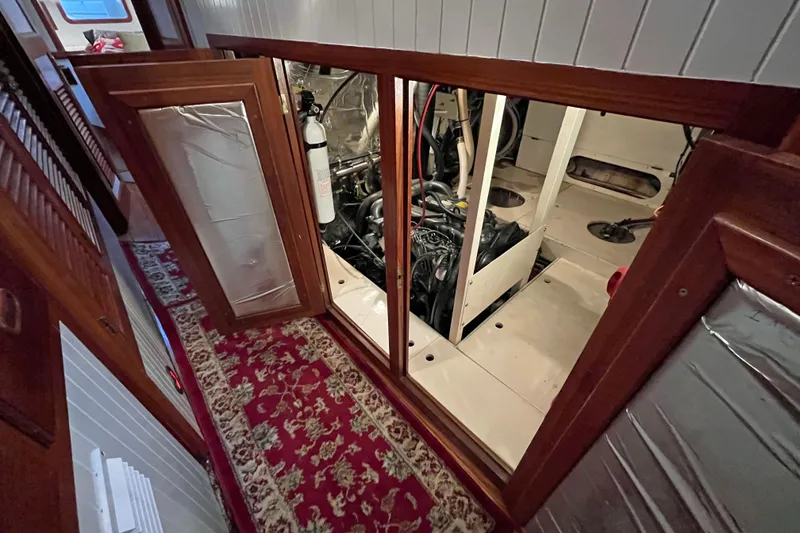 Slide: The Image of Engine room of 1987 Liberty Gatsby yacht with open wooden panels and visible machinery. - 14