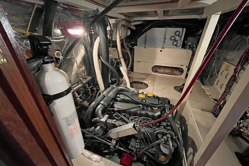 Slide: The Image of Engine room of 1987 Liberty Gatsby boat with visible fire extinguisher and mechanical components. - 16
