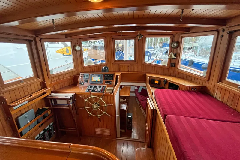 Slide: The Image of Interior of 1987 Liberty Gatsby boat with wooden helm and red seating. - 17