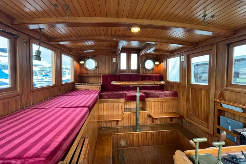 Slide: The Image of Interior of 1987 Liberty Gatsby boat with wooden paneling and red cushioned seating. - 19