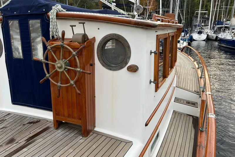 Slide: The Image of 1987 Liberty Gatsby boat with wooden deck and classic helm, docked in a marina. - 33