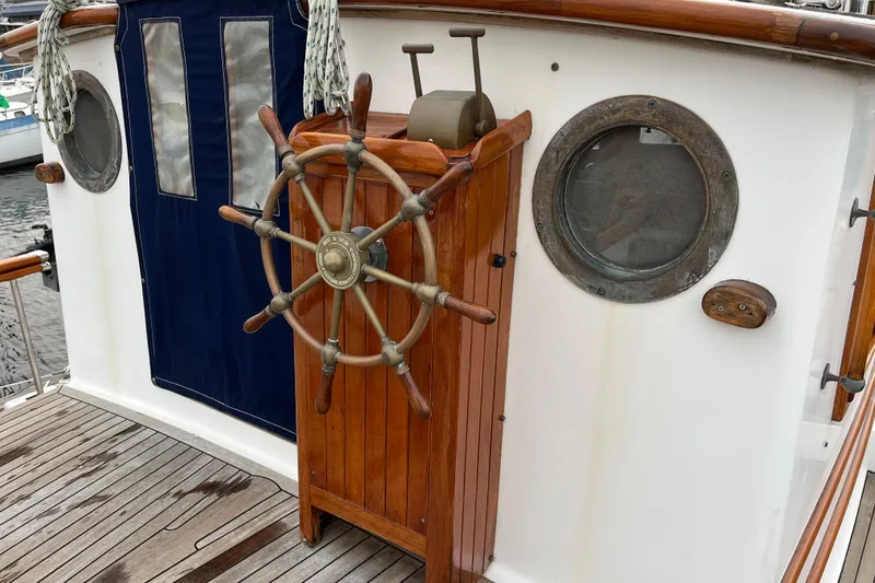 Slide: The Image of Wooden ship wheel on 1987 Liberty Gatsby boat deck, with porthole and nautical details. - 34