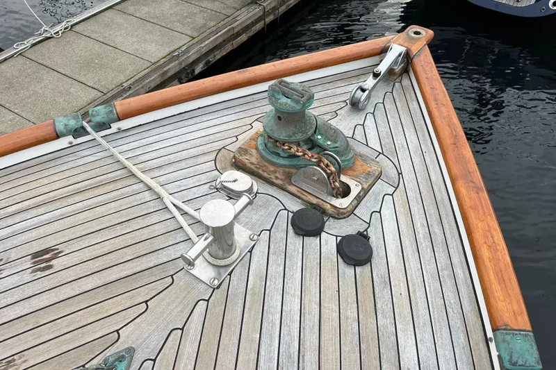 Slide: The Image of Bow of 1987 Liberty Gatsby boat with anchor chain and wooden deck details. - 42