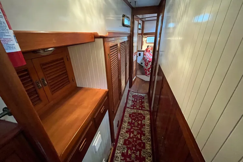 Slide: The Image of Narrow hallway in 1987 Liberty Gatsby yacht with wooden cabinets and floral carpet. - 7