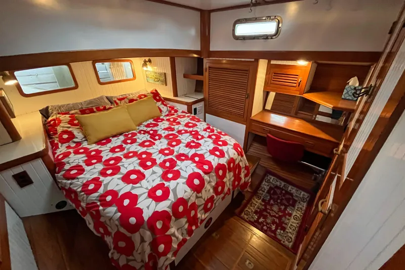 Slide: The Image of Cozy 1987 Liberty Gatsby boat cabin with floral bedding and wooden furnishings. - 9