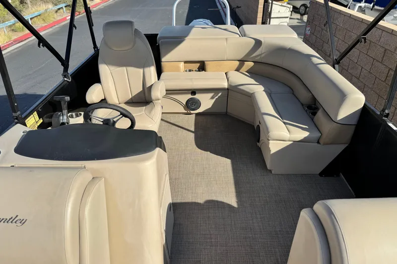 Slide: The Image of 2020 Bentley Pontoons 223 Cruise interior with beige seating and steering console. - 15