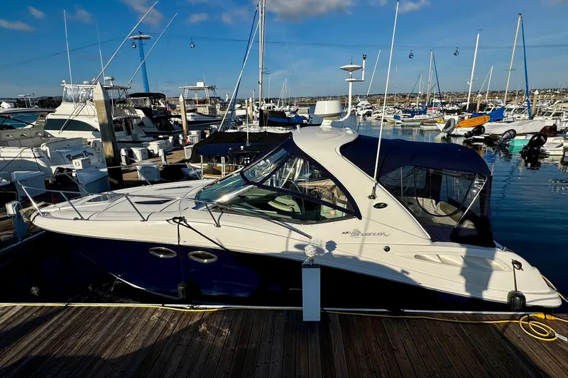 Slide: The Image of 2007 Sea Ray 290 Sundancer docked at a marina under a clear blue sky. - 1