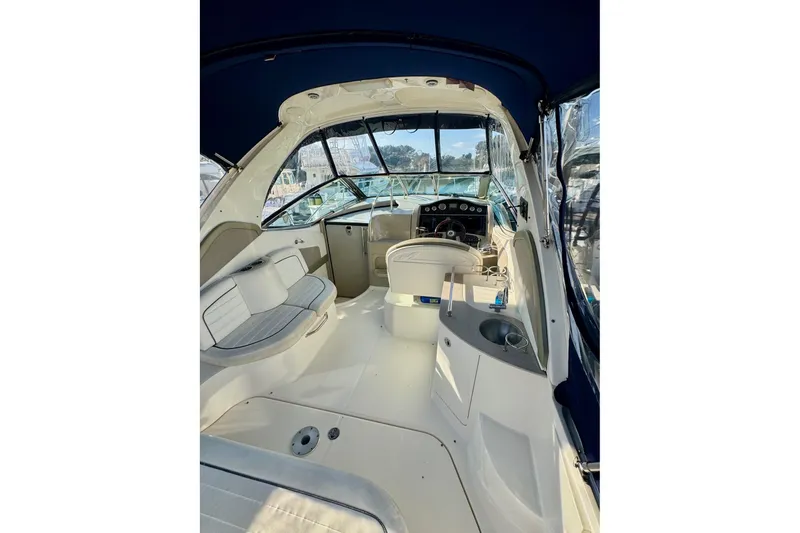 Slide: The Image of 2007 Sea Ray 290 Sundancer boat interior with seating and helm, under blue canopy. - 10