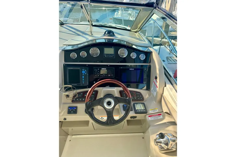 Slide: The Image of 2007 Sea Ray 290 Sundancer helm with steering wheel, gauges, and navigation equipment. - 14