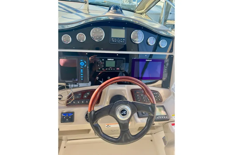 Slide: The Image of 2007 Sea Ray 290 Sundancer helm with navigation instruments and wood-accented steering wheel. - 15