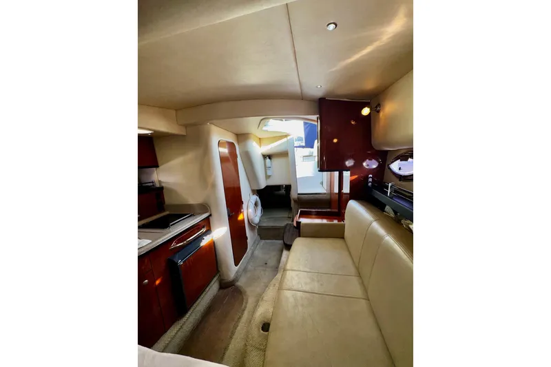 Slide: The Image of Interior of 2007 Sea Ray 290 Sundancer yacht with beige seating and wooden cabinetry. - 19