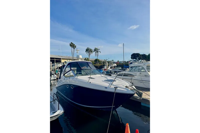 Slide: The Image of 2007 Sea Ray 290 Sundancer docked at marina under clear blue sky. - 2